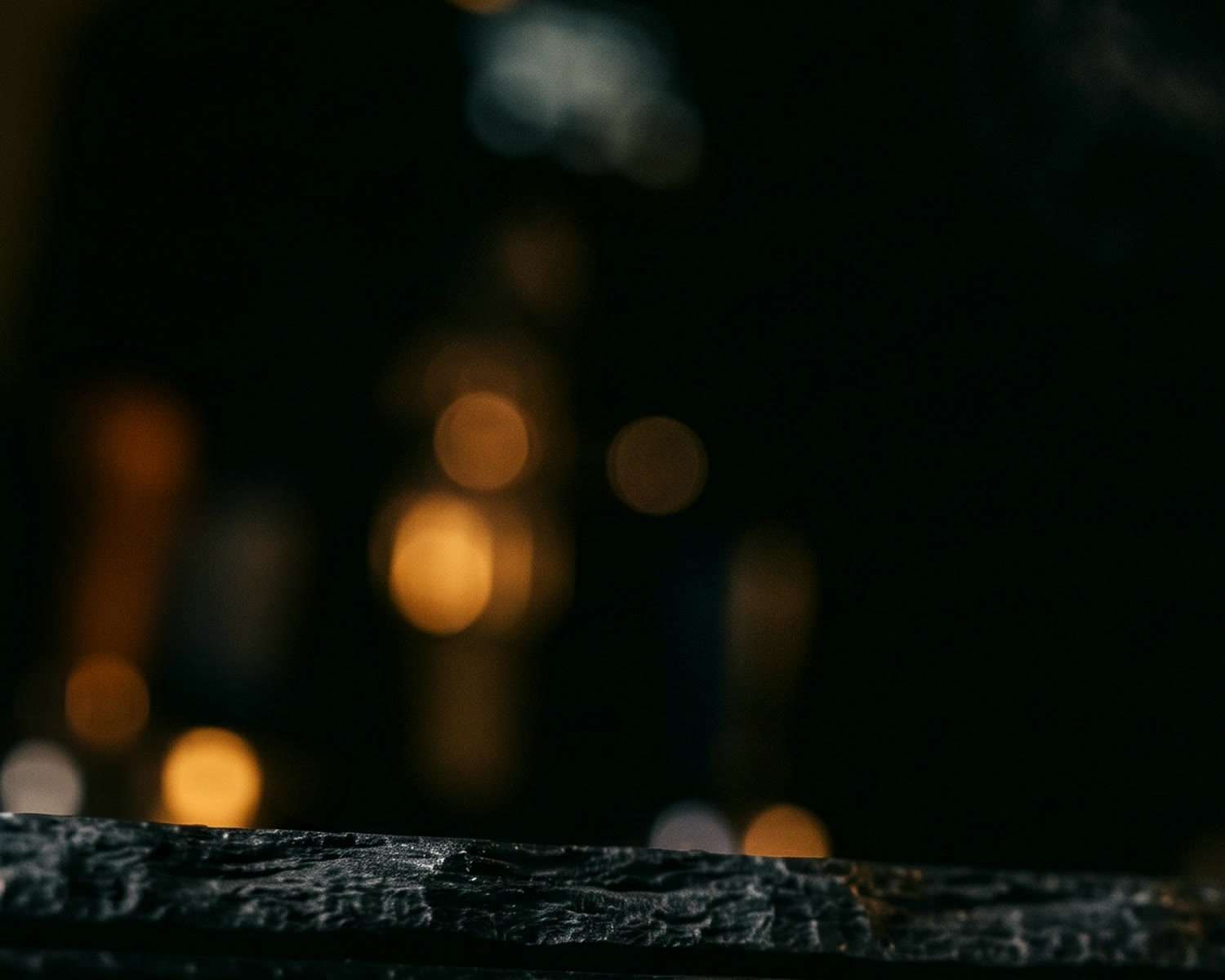 Warm lights glowing behind the dark stone bar of our tasting room